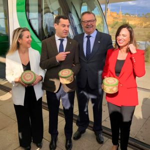 Representantes institucionales y empresariales muestran las latas de Tortas de Alcalá 2024 durante un encuentro.