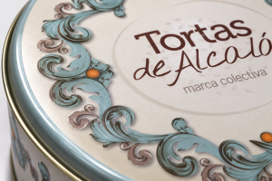 Primer plano de la tapa de la primera lata de Tortas de Alcalá, con el logotipo de la marca colectiva y motivos ornamentales azul turquesa.
